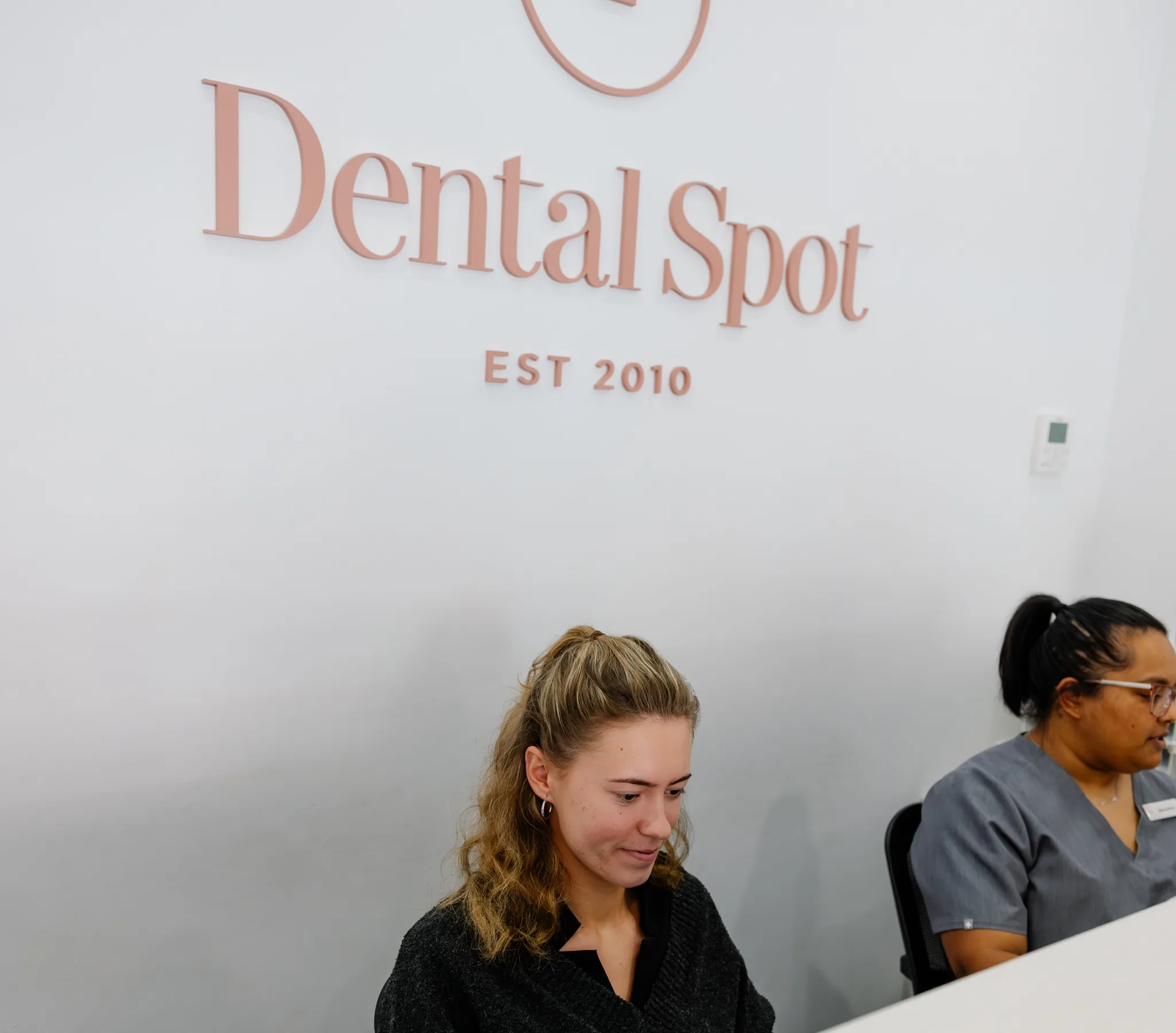 The Dental Spot reception desk under the clinic sign